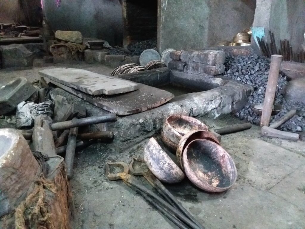 Bols tibétains en cours de fabrication artisanale dans un atelier traditionnel