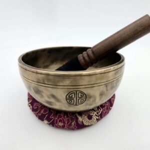 Bol chantant tibétain Full Moon 7 métaux Sol♯ 147 mm posé sur coussin avec bâton bois-cuir