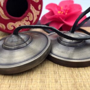 Vue de dessus de tingshas tibétaines 7 métaux 77 mm finition bronze patiné avec cordon en cuir