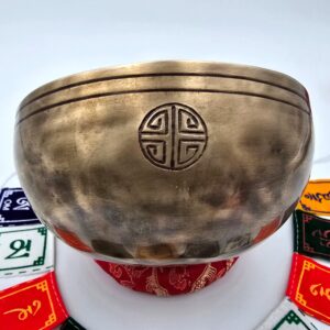 Bol chantant tibétain Full Moon 7 métaux 140 mm vue de profil avec sceau traditionnel, coussin rouge et drapeaux de prière Om Mani Padme Hum
