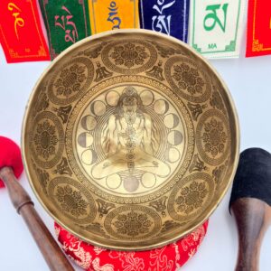 Bol chantant tibétain gravé 7 métaux vue intérieure avec silhouette en méditation chakras alignés motifs sacrés avec bâton bois cuir et mailloche sur coussin avec drapeaux de prière tibétains