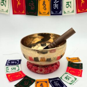 Bol chantant tibétain brut 7 métaux 620 g en Fa♯ – vue extérieure avec bâton bois sur coussin rouge et drapeaux de prière