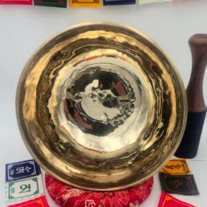 Bol chantant tibétain brut 7 métaux 1,190 kg en Fa♯ – vue intérieure brillante avec coussin rouge, bâton bois-cuir et drapeaux de prière