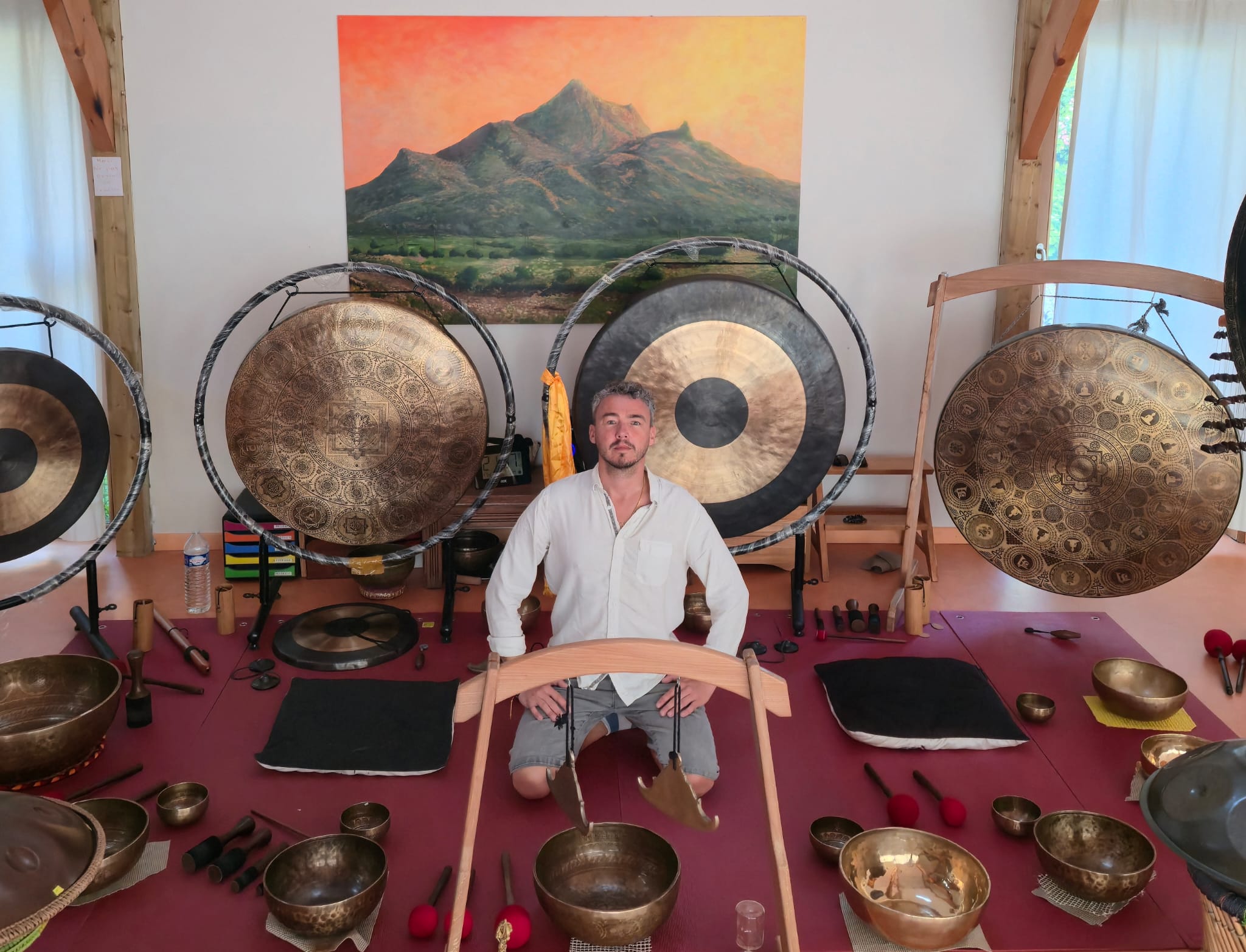Praticien entouré de bols tibétains et de gongs