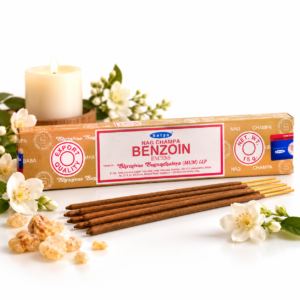 Boîte d'encens indien Satya Benzoin 15 g avec fleurs blanches et bougie sur fond clair