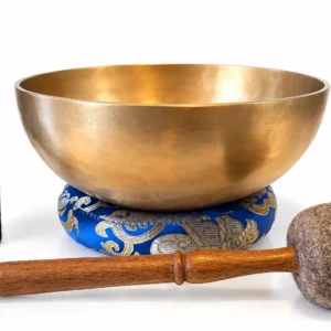 Bol tibétain thérapeutique en Do de 1 270 g et 220 mm, finition dorée, présenté sur un coussin bleu brodé avec bâton de rotation et mailloche en feutre.