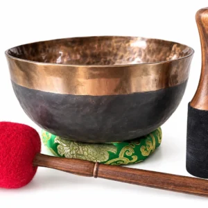 Bol tibétain Ulta Bathi en La de 2 020 g et 258 mm, patine sombre et bordure cuivrée, sur coussin vert brodé avec bâton de rotation et mailloche rouge.
