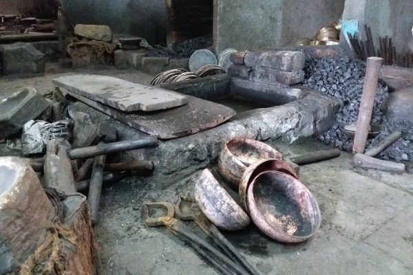 Bols tibétains en cours de fabrication artisanale dans un atelier traditionnel