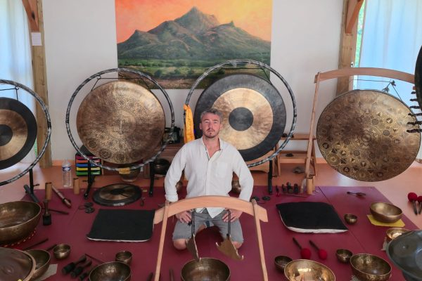 Hugo entouré de bols tibétains et de gongs en Normandie